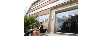 Two students sit on steps in front of a building